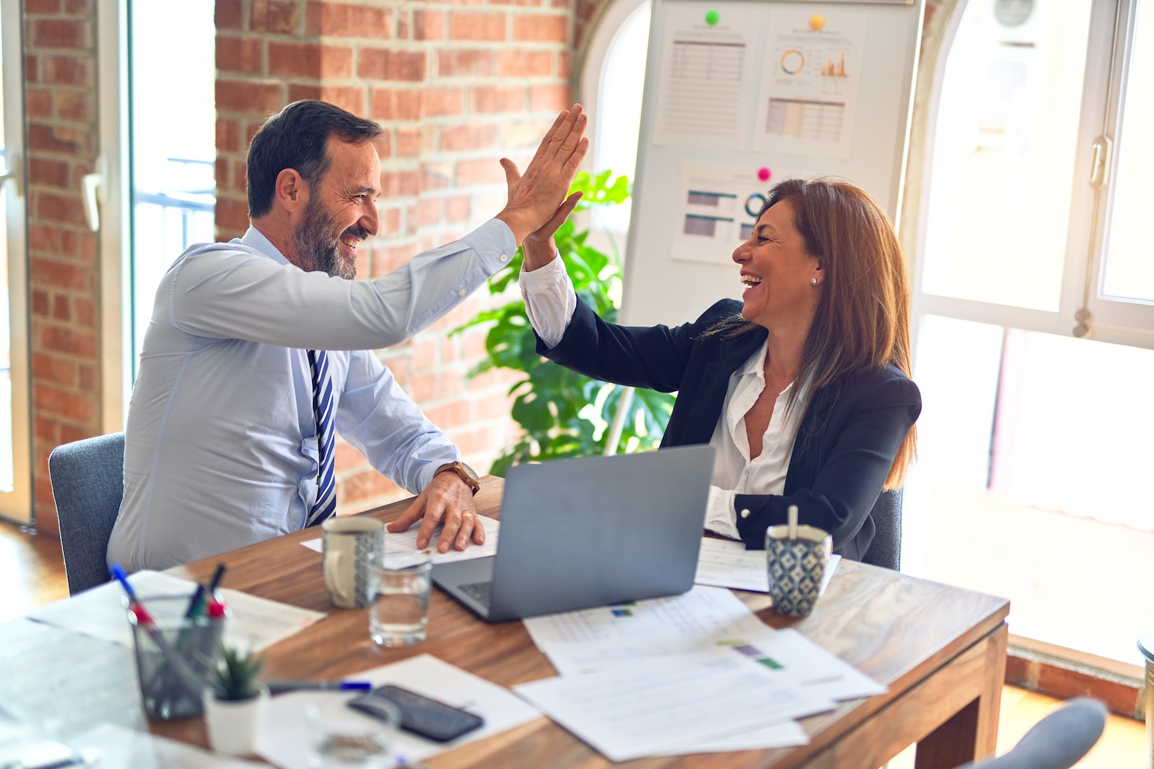 two office workers high five