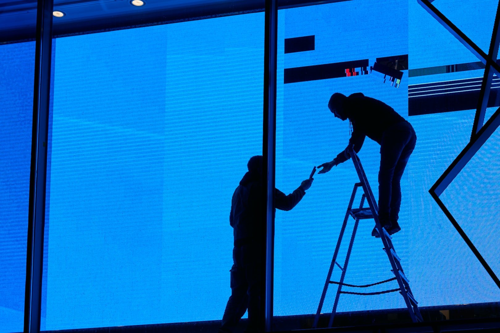 man on ladder cleaning blinds